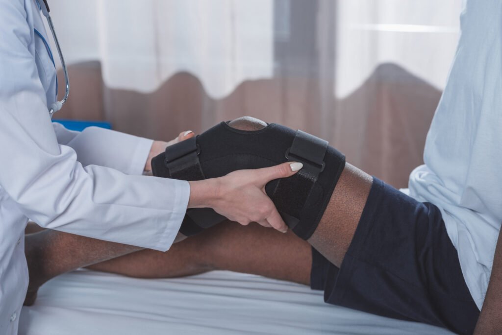 Cropped image of doctor putting on knee brace to a 2021 08 29 18 18 42 utc scaled 1